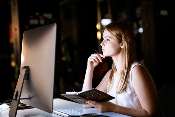 Businesswoman in her office at night working late.