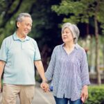 Happy Asian mature couple is walking on the street