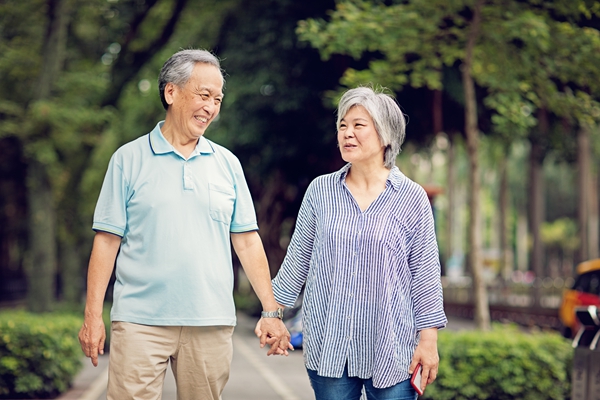 Happy Asian mature couple is walking on the street
