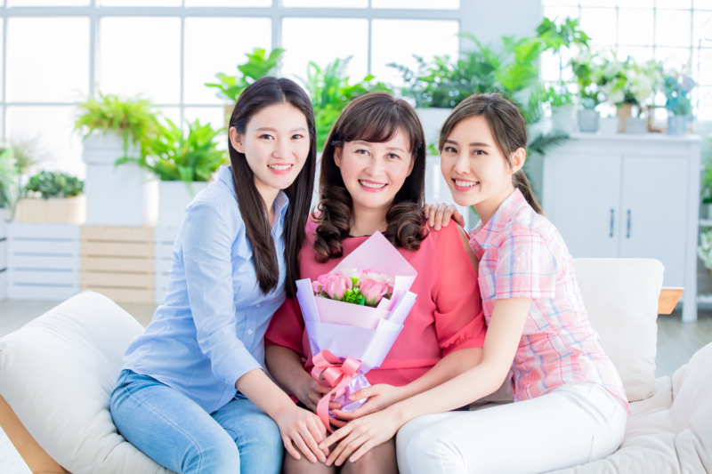 Two,Daughters,Give,Flowers,To,Her,Mom,And,Celebrate,Happy