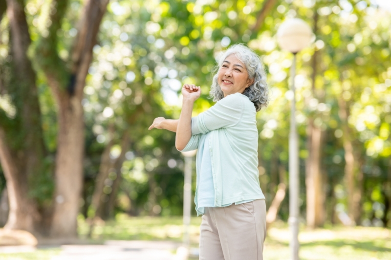 Old,Aged,Asian,Woman,Grandma,Crossing,Both,Arms,Stretching,While